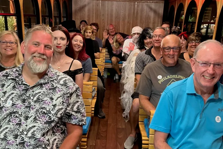 group of patrons on the HAUNTED tour, posing and smiling - some dressed up in costume