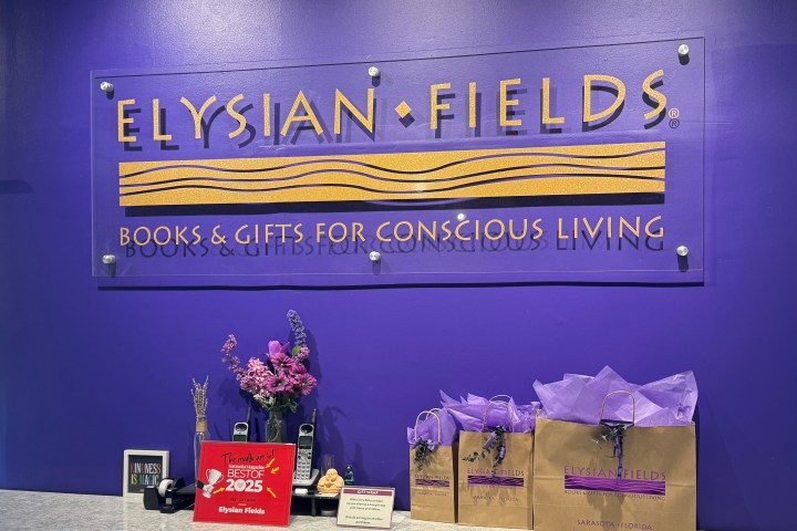 Elysian Fields store sign on purple wall above counter with gifts and awards.