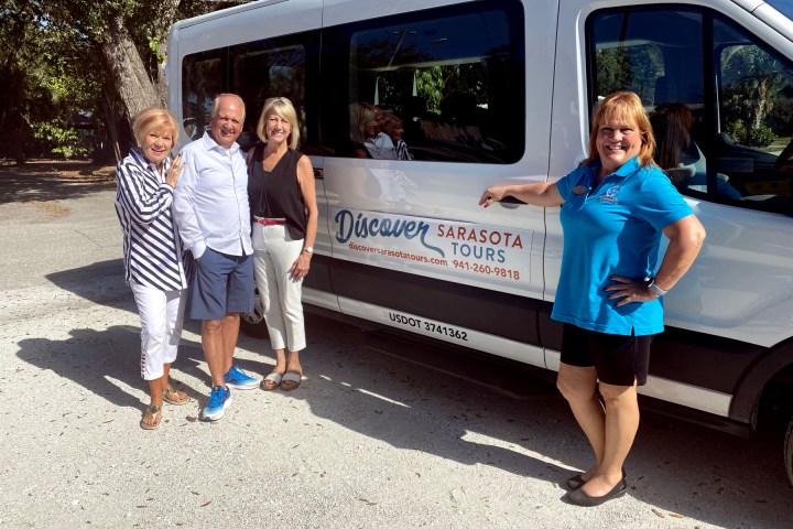 a group of people standing in front of a bus