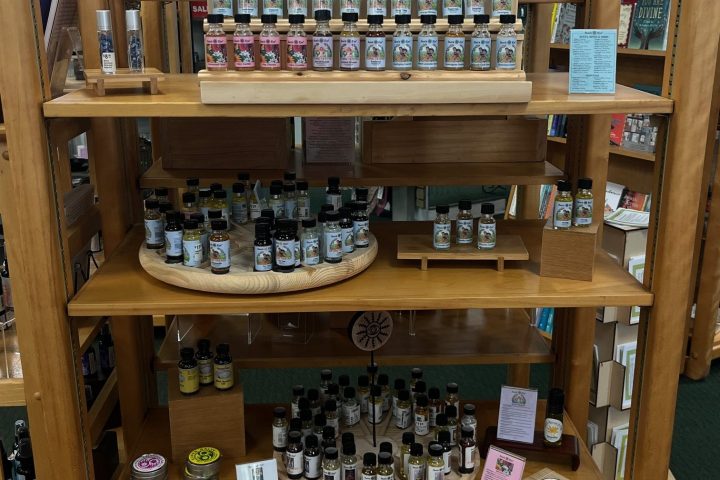 Shelf with essential oils and diffusers displayed on wooden shelves in a store.