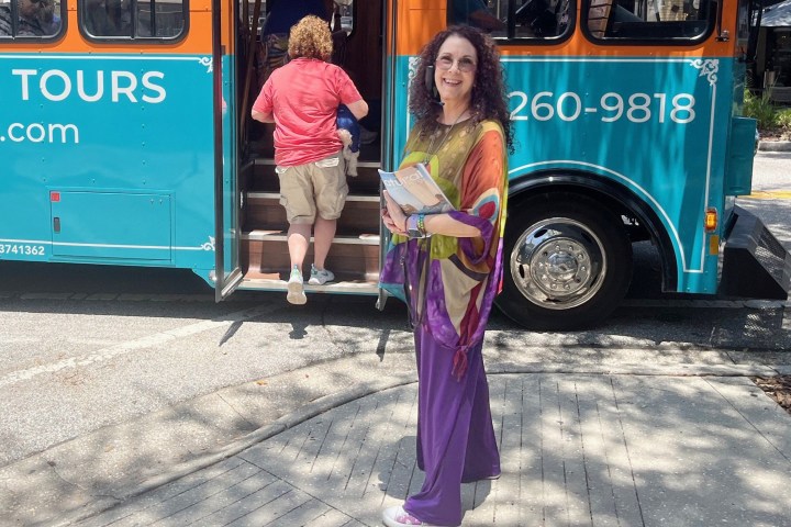 Deni, psychic tour guide in front of Discover Sarasota Tours trolley