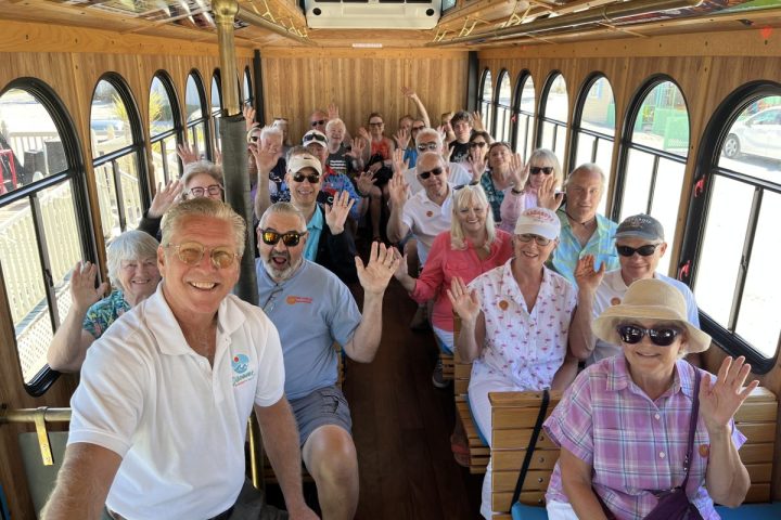 a group of people posing for the camera, city tour guide Steve on the trolley with his tour group