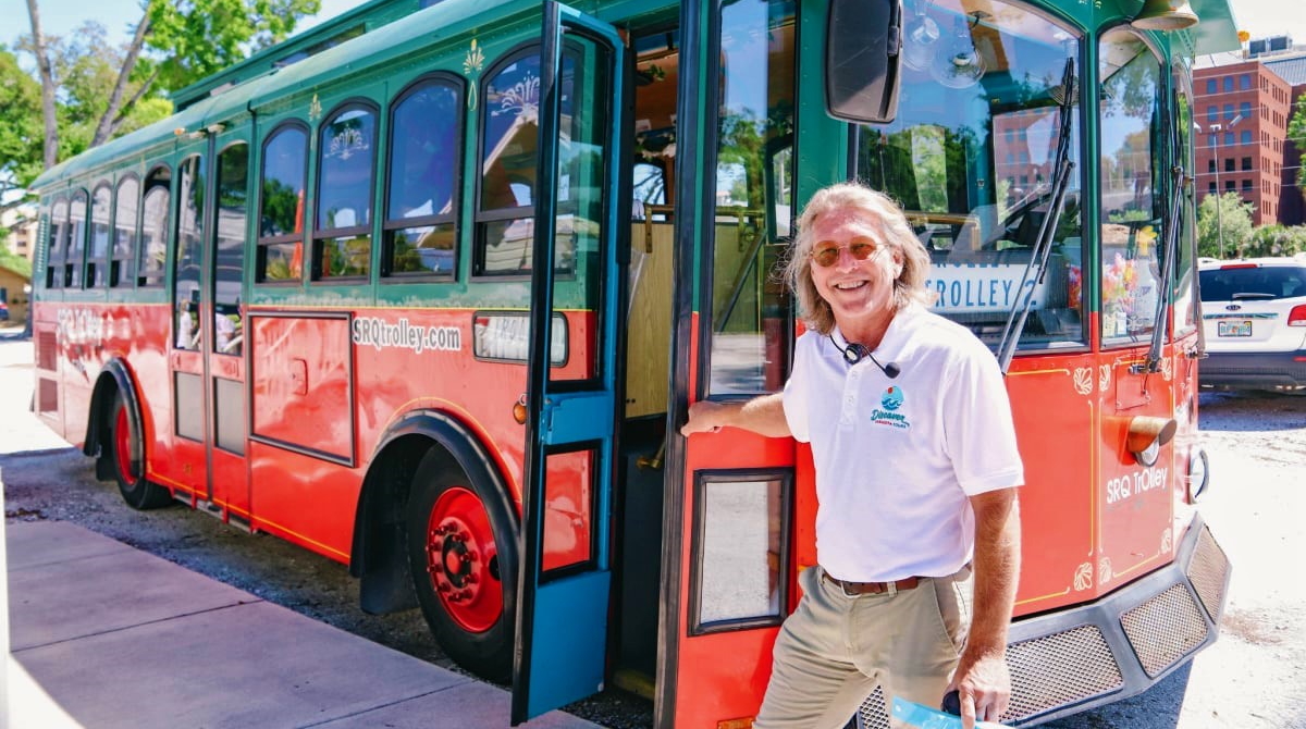 Steve-with-Trolley_image001-adjusted_1200x670 a man standing in front of a bus