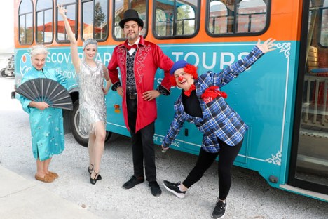 a group of people standing in front of a bus