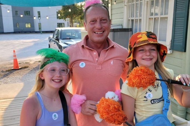 a woman standing in front of a group of people posing for the camera