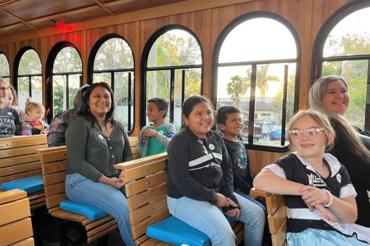 a group of people sitting on a bench posing for the camera