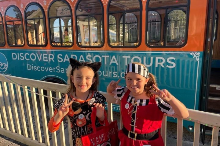 a group of people sitting on a bench in front of a bus