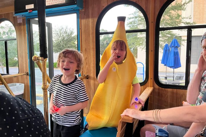 a group of people sitting at a table with a hot dog