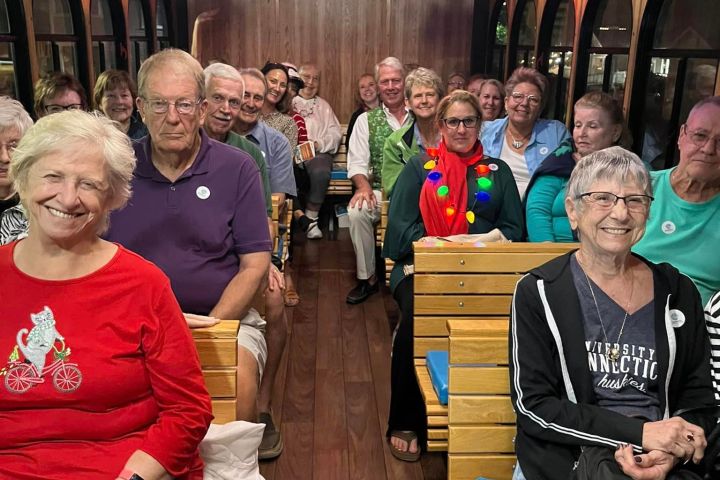 a group of people sitting on a bench posing for the camera