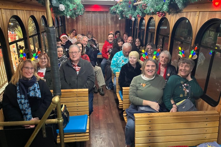 a group of people sitting on a bench posing for the camera