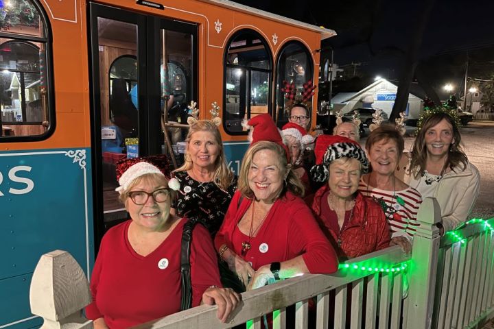 a group of people sitting on a bench posing for the camera