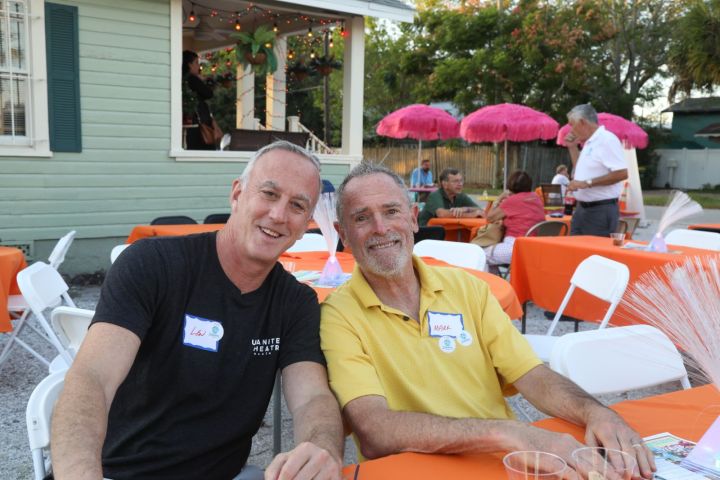a group of people sitting at a table with an umbrella