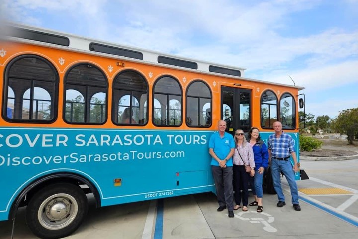 a group of people standing in front of a bus