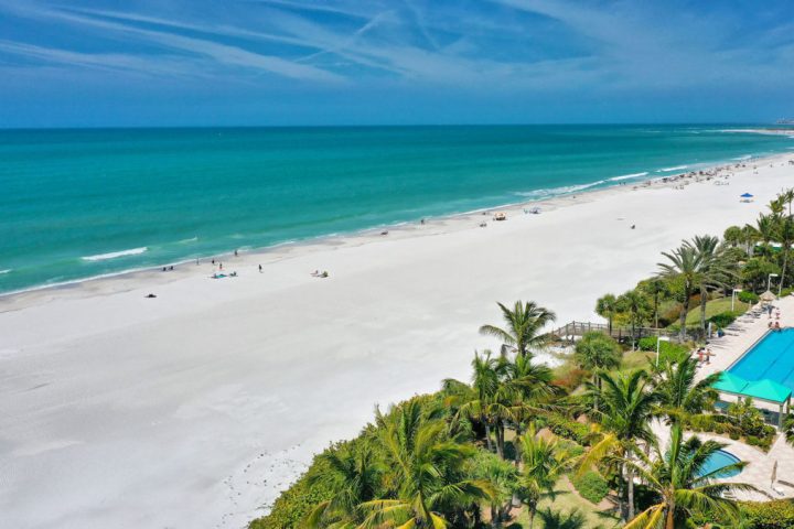 a group of lawn chairs sitting on top of a sandy beach