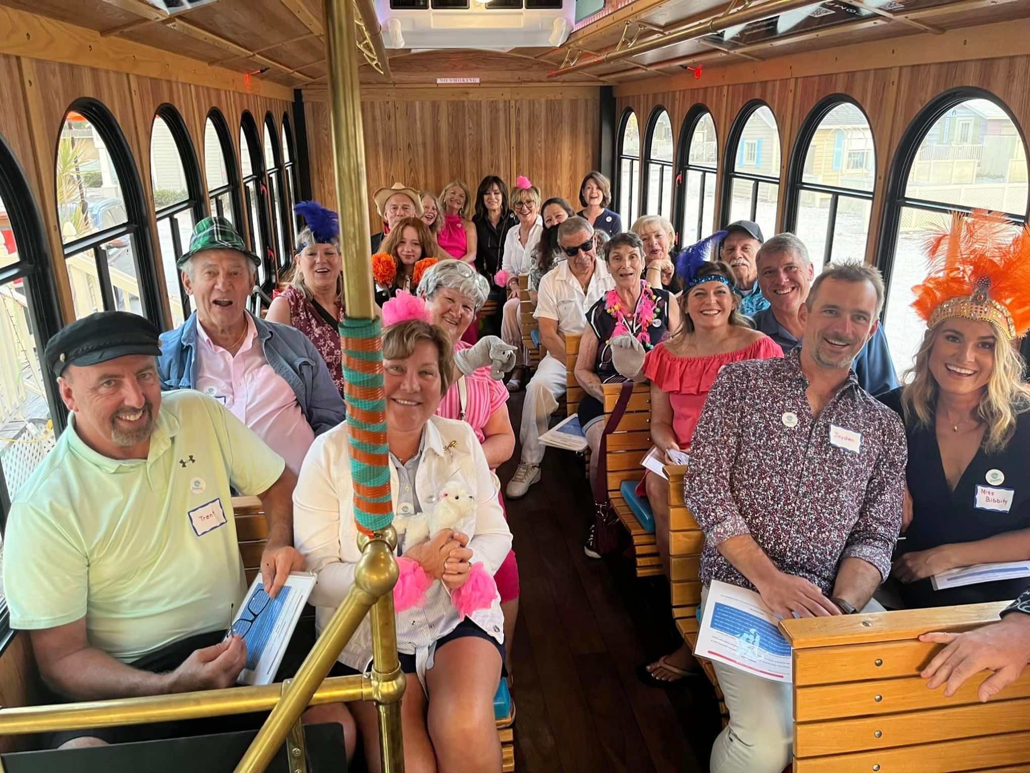 a group of smiling and excited people posing for the camera in costume on the trolly for murder mystery show - Who Killed the Circus Queen?