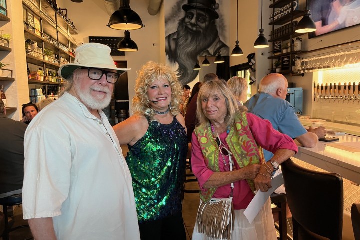 a group of people standing at 99 bottles with Michelle the lead performer