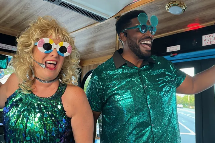 the hosts of sing-along tour on discover sarasota tours trolley singing and leading the crowd in sunglasses