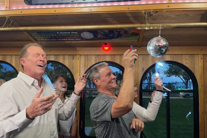 People enjoying a party in a trolley with a small disco ball inside.