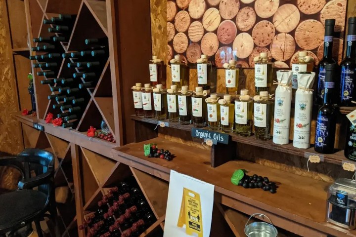 Wine rack and organic oils displayed on wooden shelves.