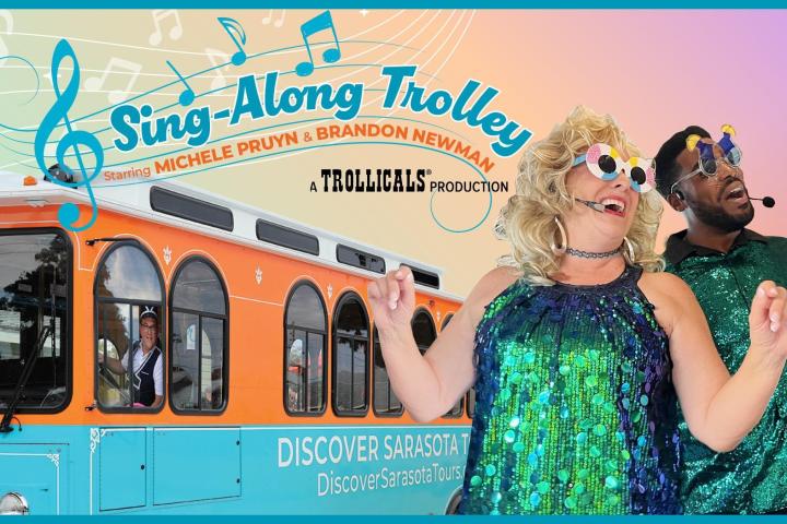 Two people in sequined outfits singing near a colorful trolley with musical notes.