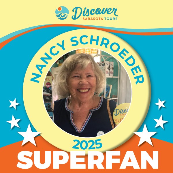 Smiling woman in front of a 'Discover Sarasota Tours' backdrop with 'Superfan 2025' text and stars around her.