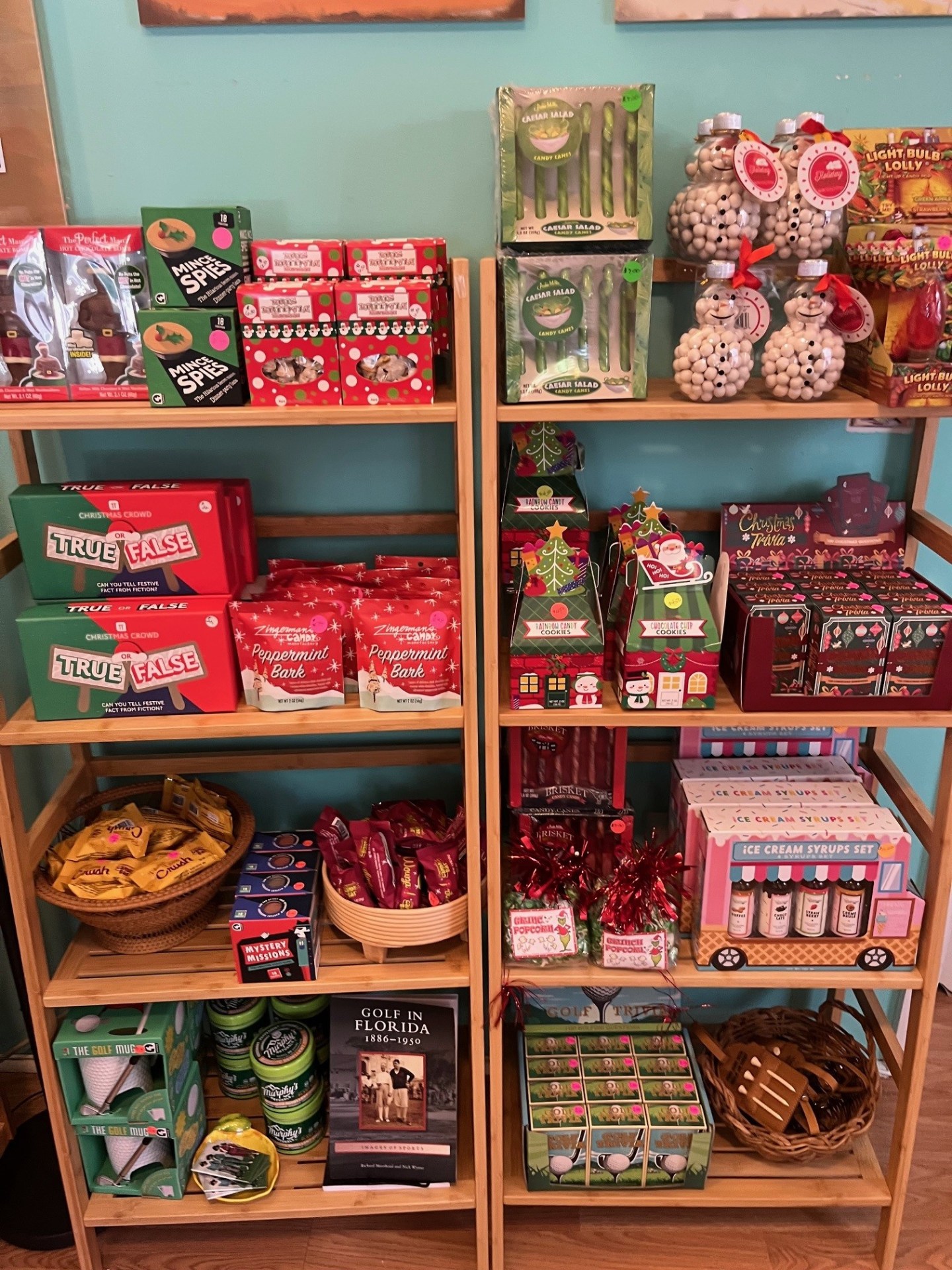 Wooden shelves with holiday candies, tins, and festive packaging in a shop display.