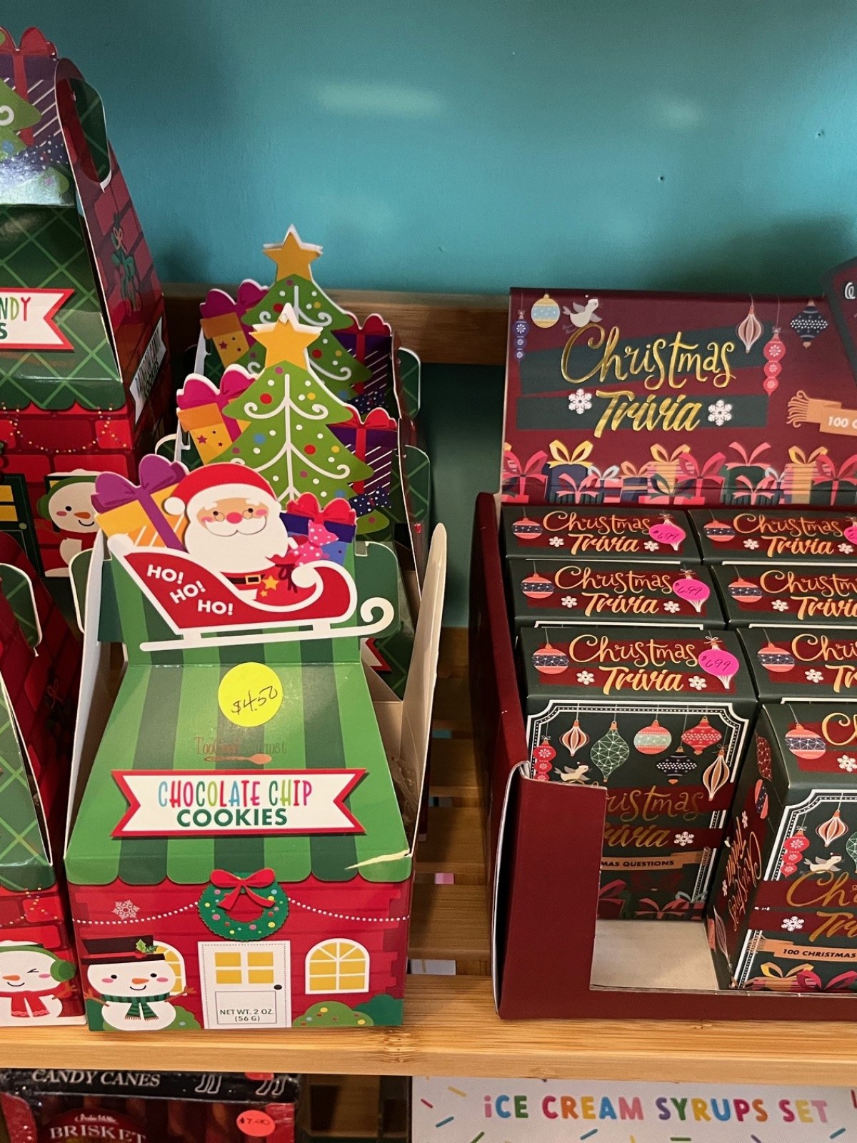 Festive cookie boxes and Christmas trivia on wooden shelves.