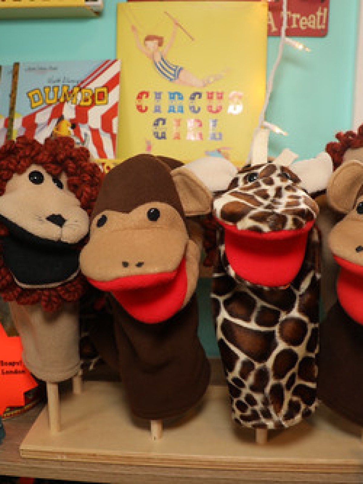 Plush animal puppets on display in a brightly colored room with circus-themed decor.