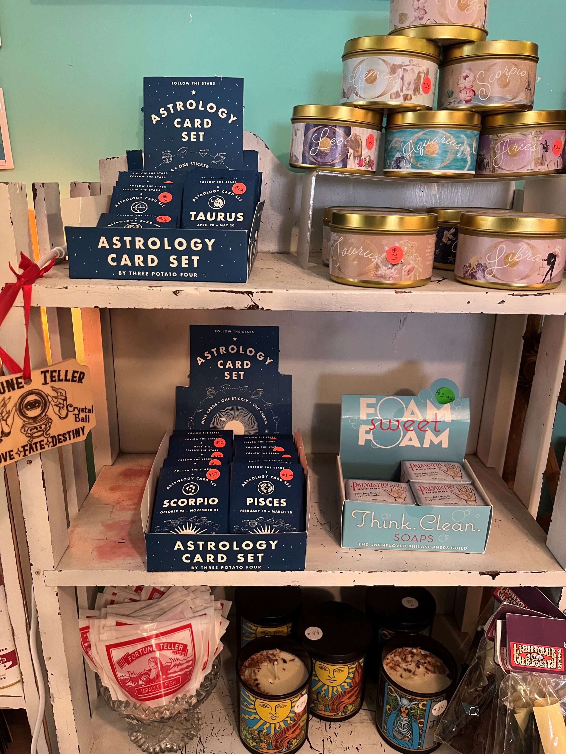 Shelves with astrology card sets, zodiac candles, and soaps.