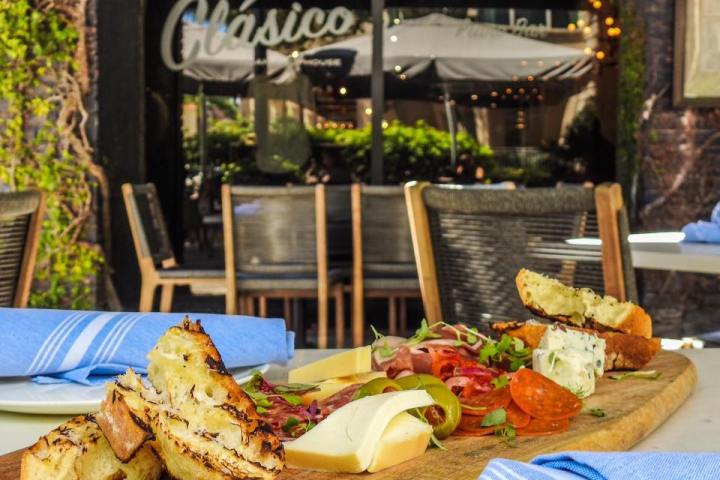 Charcuterie board with meats, cheeses, and bread on a wooden table.
