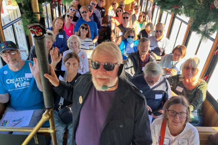 Group of people smiling inside a decorated trolley.