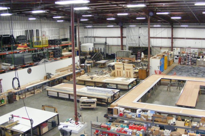 Large warehouse with workbenches and various construction materials.