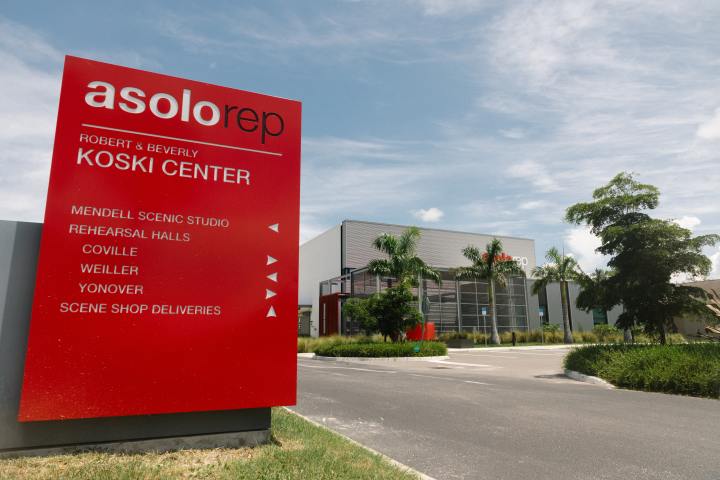 Sign for Asolo Rep Koski Center with building and palm trees in background.