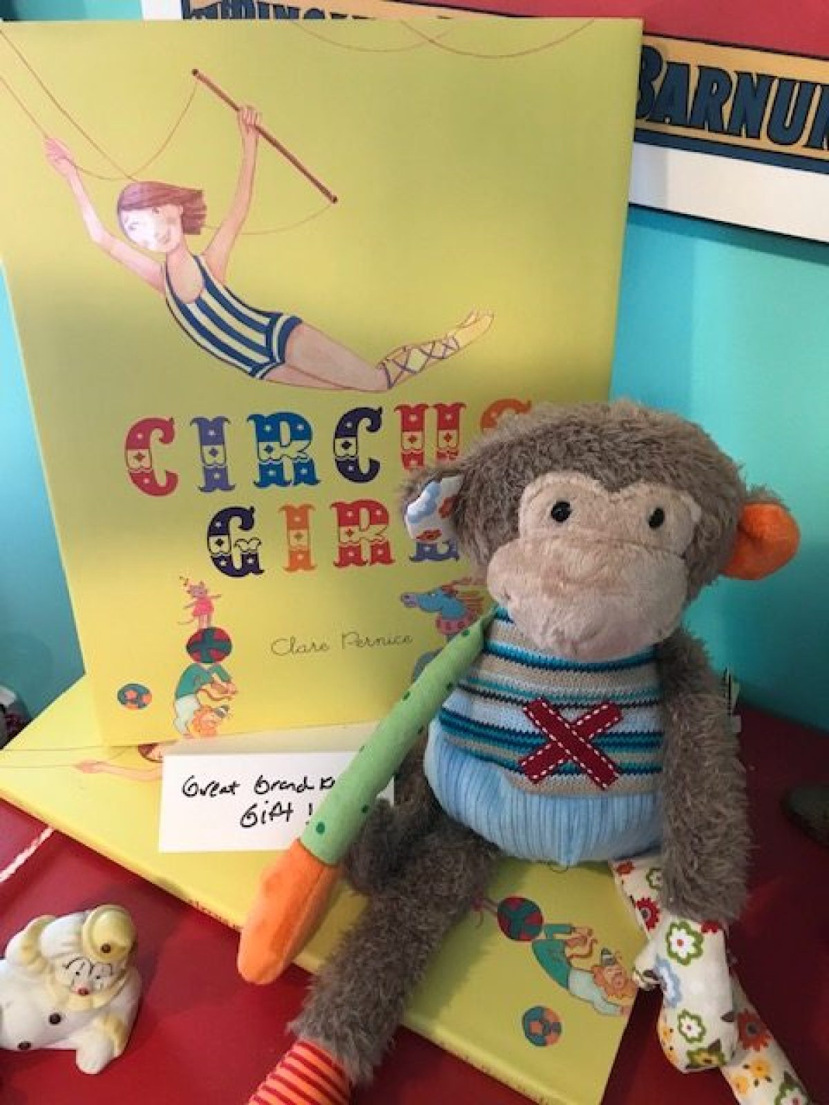 Monkey plush toy next to a 'Circus Girl' book cover.